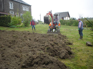 Marc ploegt de moestuin met de graafmachine